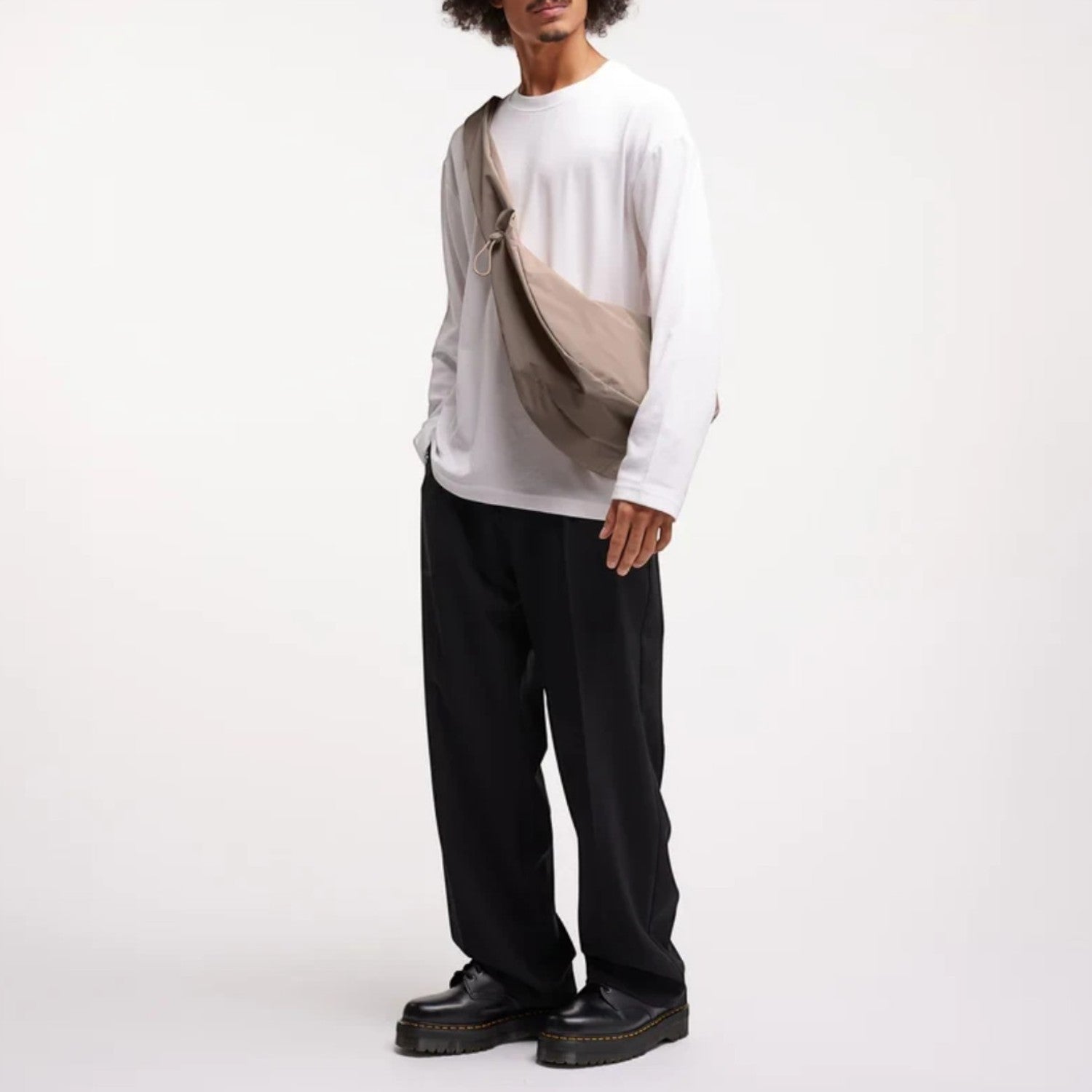 Lieblingstasche Moon Bag Ruffle Large in beige, worn as a crossbody bag by a man in a white long-sleeve shirt.