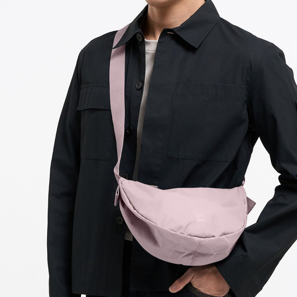 Lieblingstasche Moon Bag Small in dusty pink worn as a crossbody bag by a man in a black shirt