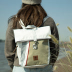 Lieblingstasche Möwe backpack in white and sage green canvas worn by a woman outdoors near the water