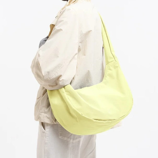 Lieblingstasche Moon Bag Ruffle Large in pale yellow, worn as a shoulder bag with a soft, crescent-shaped design.