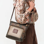 Woman wearing a Lieblingstasche multi-textured cross-body bag with brown and patterned panels