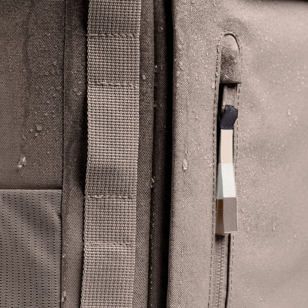 Lieblingstasche Pro Pack backpack in taupe canvas with water droplets, featuring adjustable straps and a zip pocket.