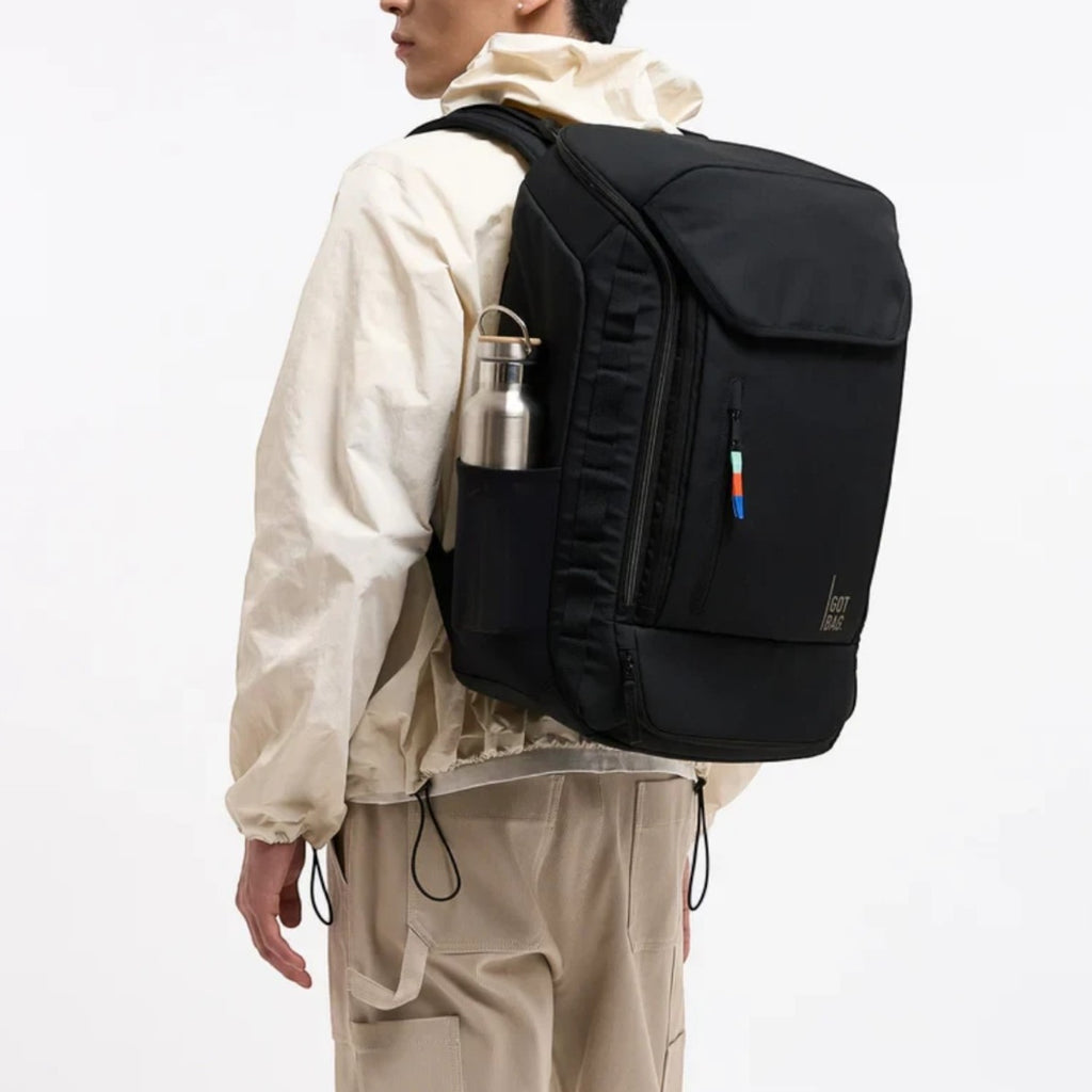 Lieblingstasche Pro Pack Travel black recycled plastic backpack worn by a man with a side water bottle pocket