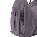 Lieblingstasche slouchy bag in dusty purple nylon with a convenient side pocket holding a smartphone