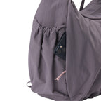 Lieblingstasche slouchy bag in dusty purple nylon with a convenient side pocket holding a smartphone