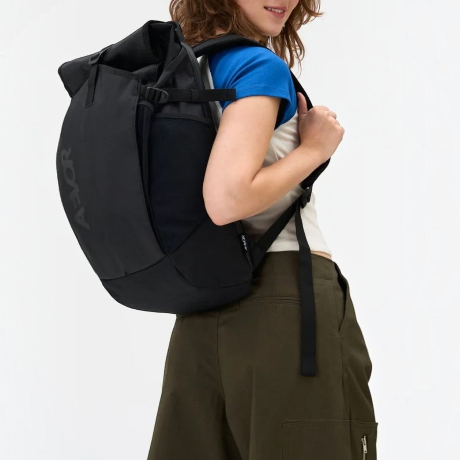 Lieblingstasche Roll Pack 2.0 black backpack with rolltop closure worn by a woman against a white background
