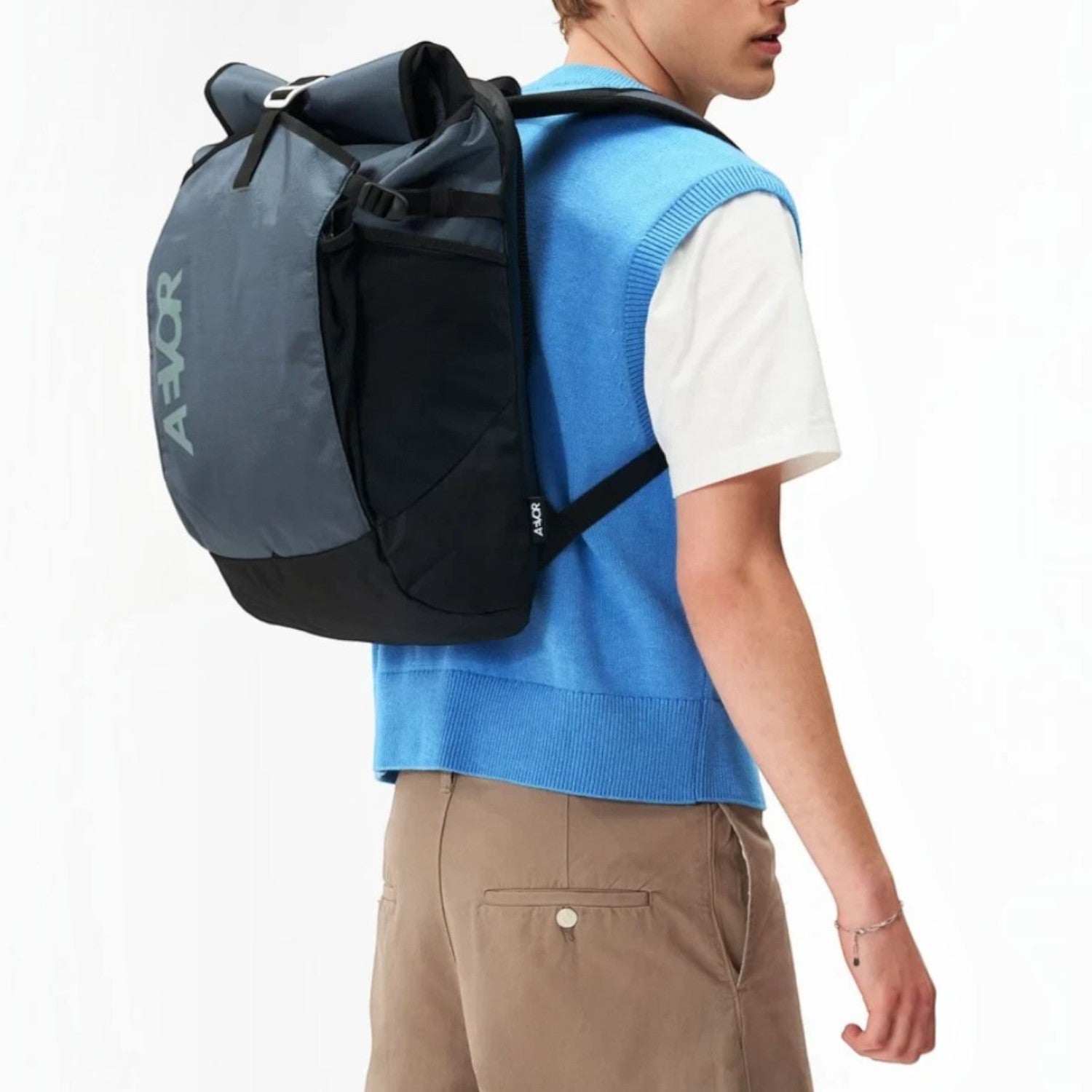 Lieblingstasche Roll Pack 2.0 grey and black rolltop backpack worn by a man in a blue sweater vest