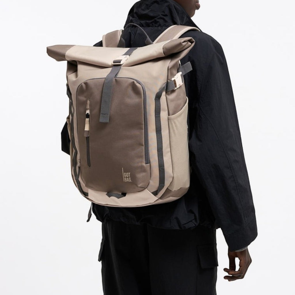 Lieblingstasche Rolltop Adventure backpack in beige and brown with grey accents, worn by a person.