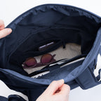 Lieblingstasche Rolltop Easy navy blue backpack interior with laptop, sunglasses, and phone