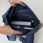 Lieblingstasche Rolltop Easy Small backpack in navy blue canvas, showing interior with laptop, book, and water bottle.