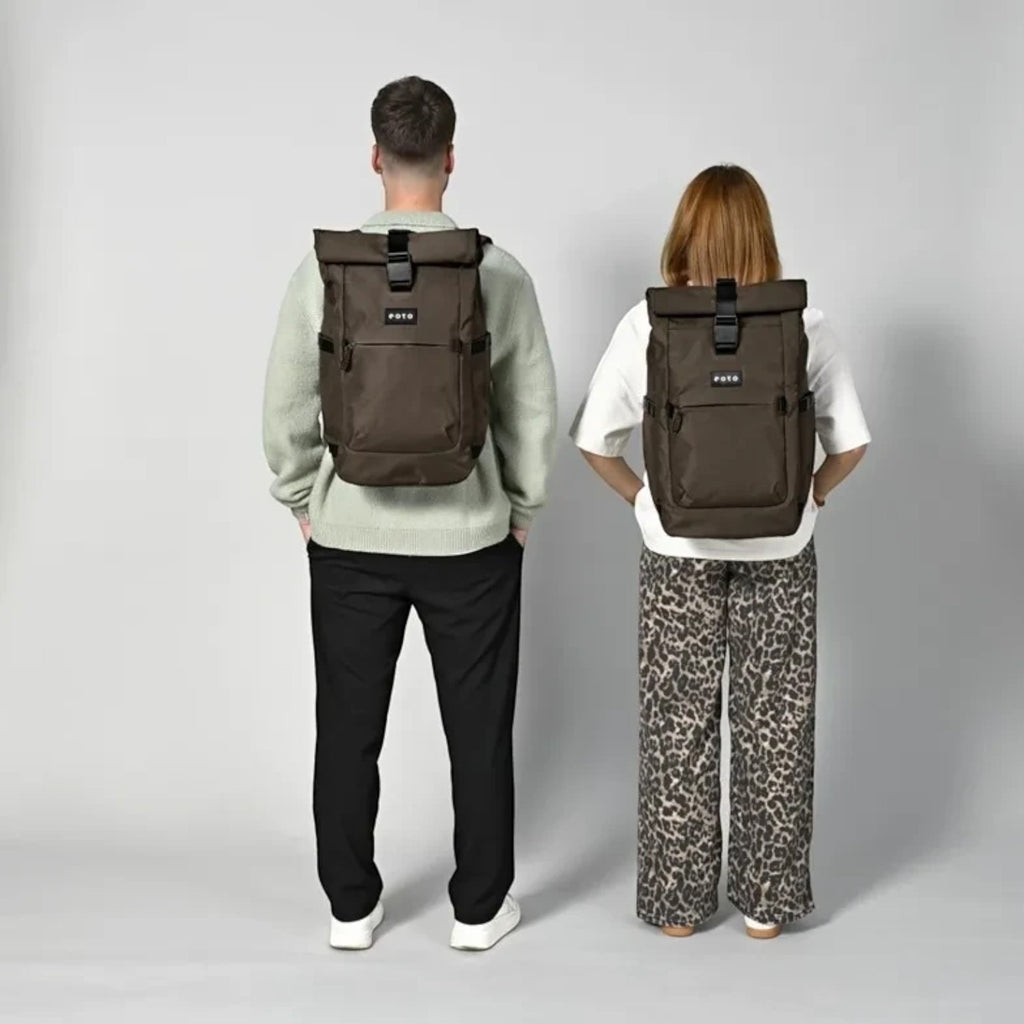 Lieblingstasche Rolly32 brown rolltop backpack worn by a man and a woman against a light grey studio background