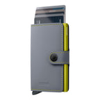Lieblingstasche Secrid Miniwallet Matte in grey leather with a lime green aluminium card protector and snap closure.
