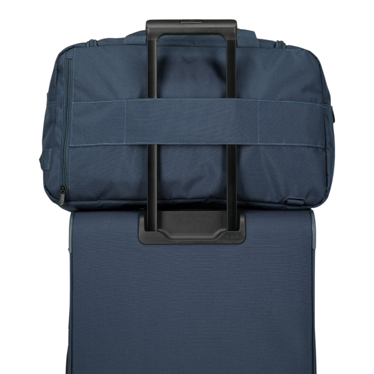 Lieblingstasche Skaii weekender rucksack in navy blue attached to a rolling suitcase handle for travel.