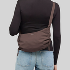 Lieblingstasche Skara Small brown crossbody bag worn by a woman in a black long-sleeve top and blue jeans