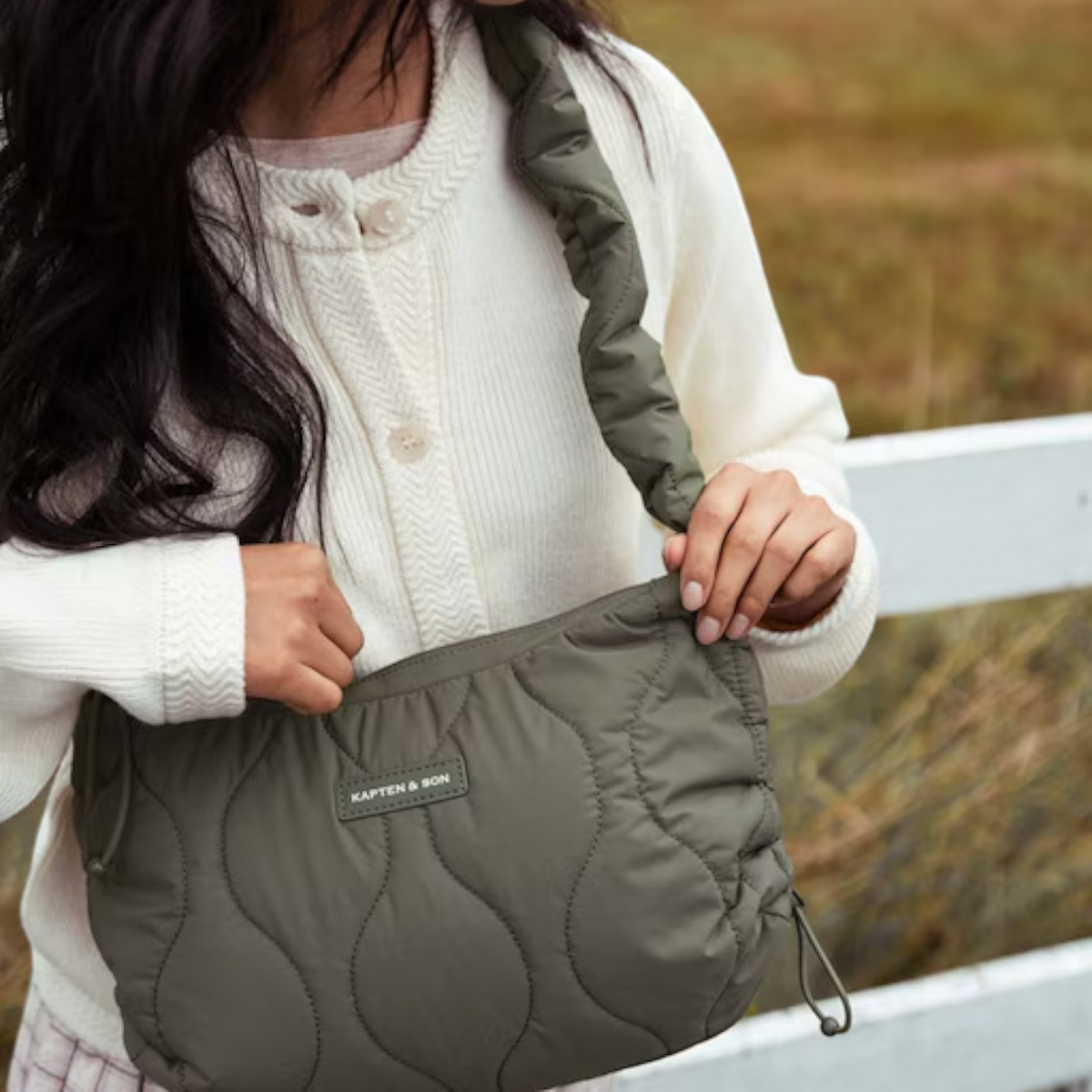 Lieblingstasche Skara Small Quilted bag in olive green with a soft ruched shoulder strap worn by a woman