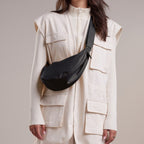 Lieblingstasche small black nylon moon bag worn crossbody by a woman.