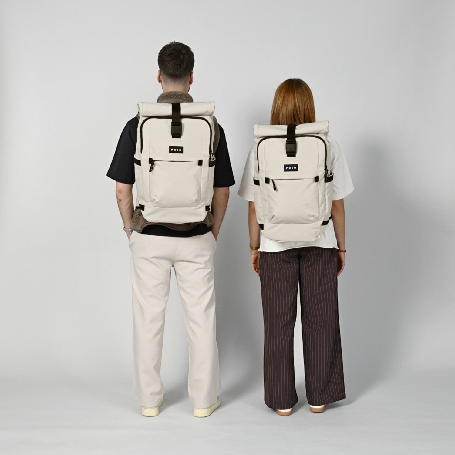 Lieblingstasche Tall41 rolltop travel backpacks in beige worn by a man and woman against a plain grey background
