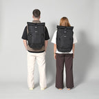 Lieblingstasche Tall41 black rolltop travel backpack worn by a man and woman showing size and fit