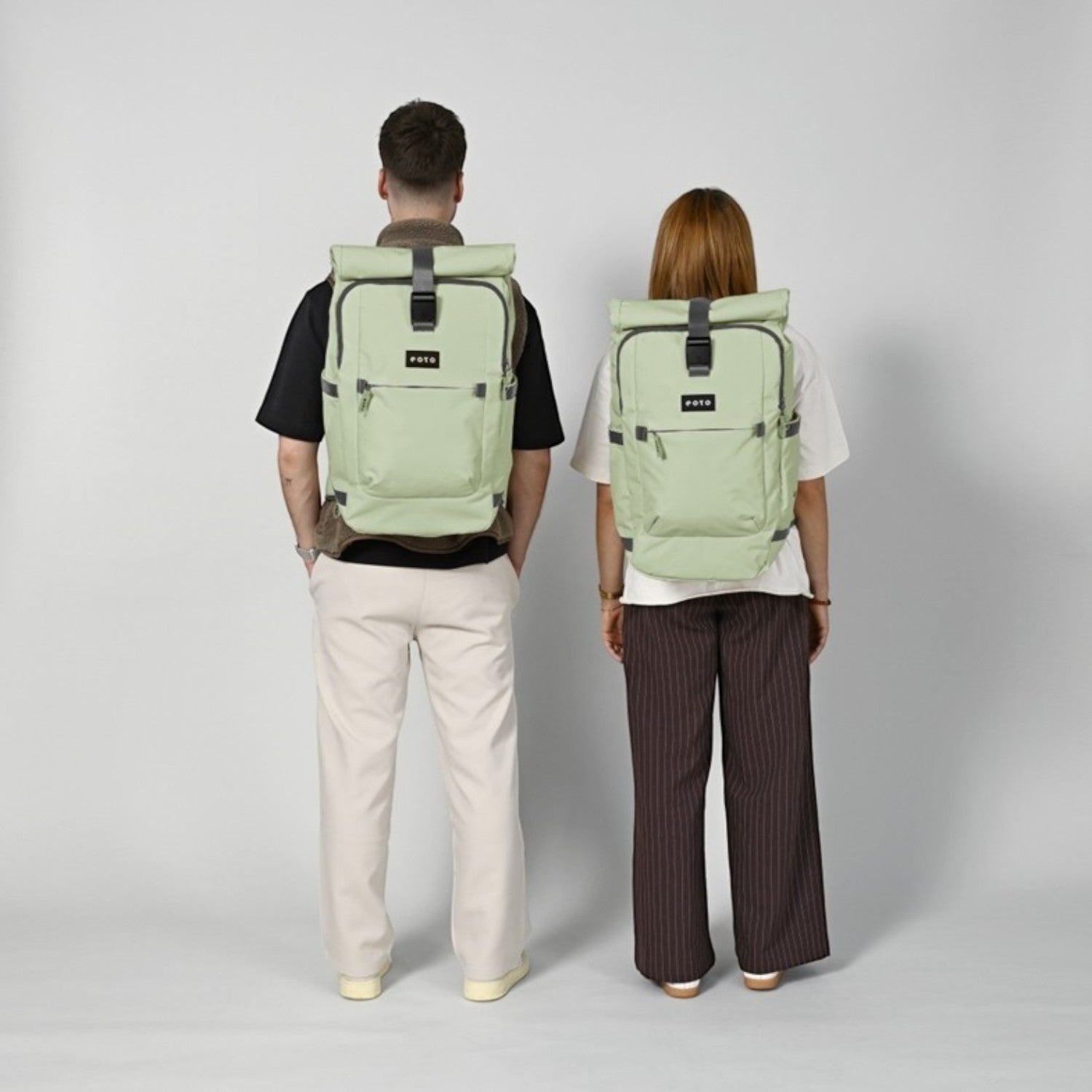Two people wearing sage green Lieblingstasche Tall41 rolltop backpacks, showing back view and ergonomic design.