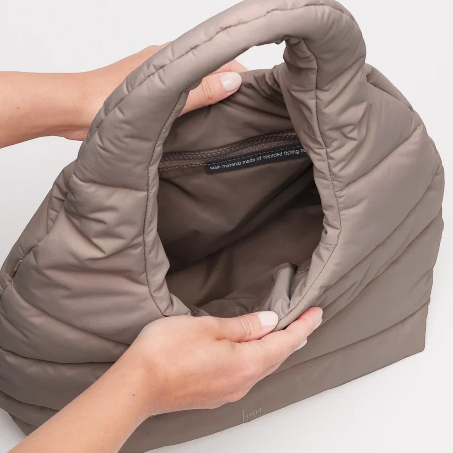 Lieblingstasche wavy puffer shoulder bag in taupe made from recycled materials, shown with an open interior.