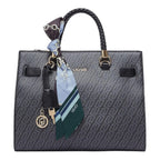 Lieblingstasche Tote M handbag in black with a monogram pattern, braided handles, and a decorative silk scarf charm.