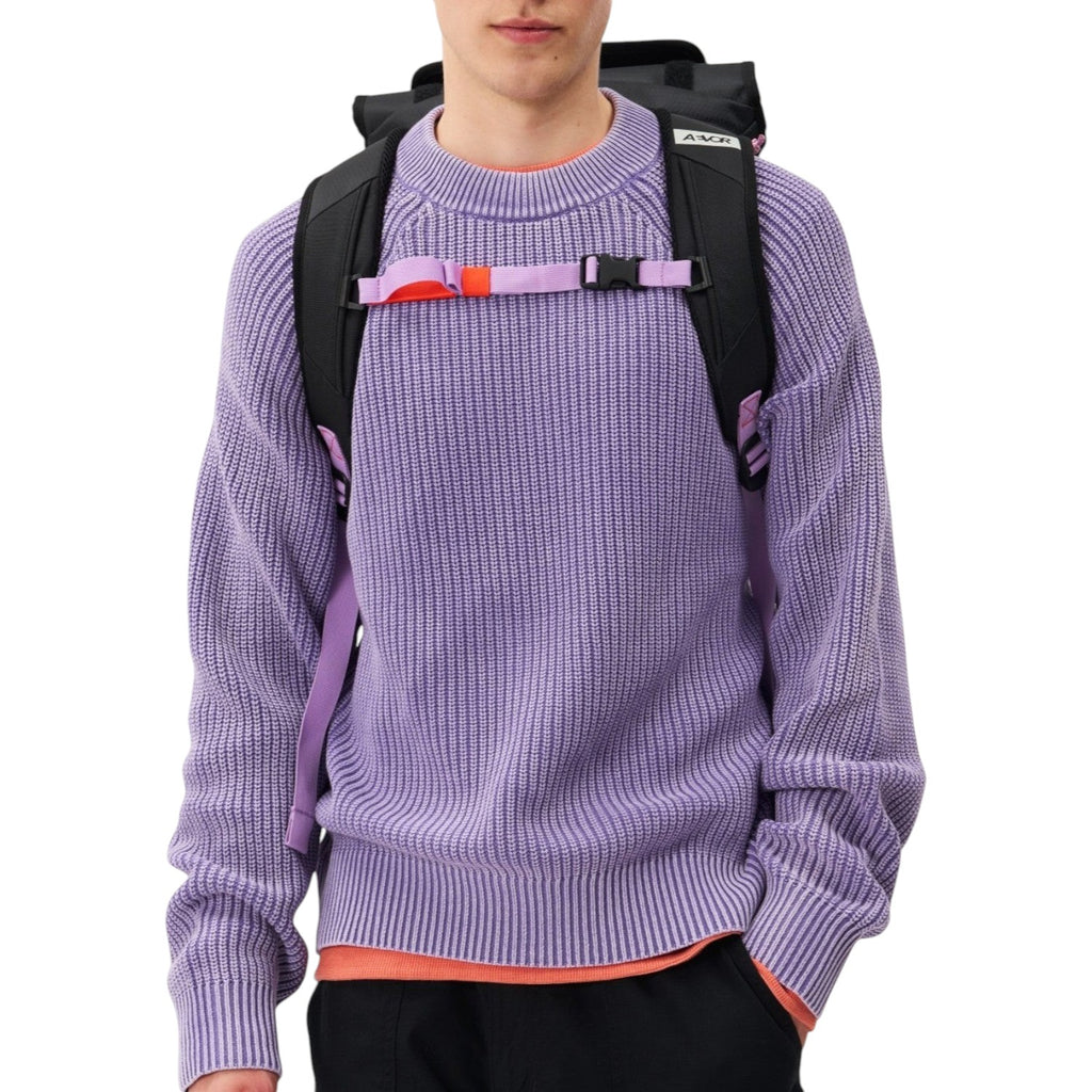 Lieblingstasche Trip Pack black backpack with purple straps worn by a man in a lavender sweater