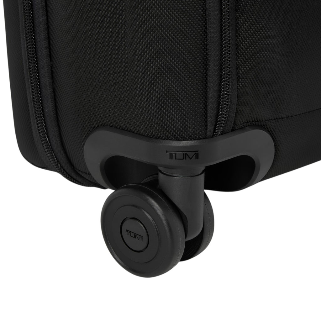 Close-up of the durable black wheel and Tumi logo on a Lieblingstasche Tumi Alpha Compact Carry On suitcase
