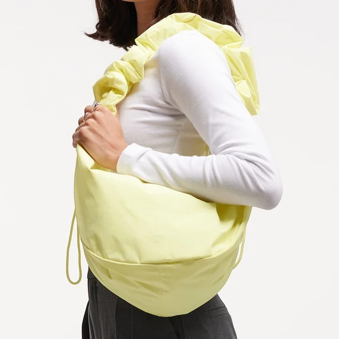 Lieblingstasche Moon Bag Ruffle Large in pastel yellow with a gathered shoulder strap worn over the shoulder