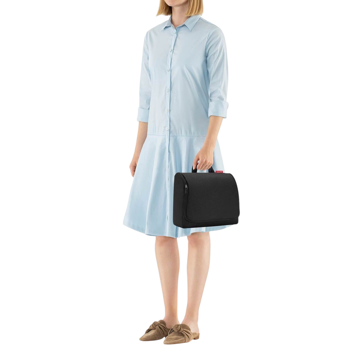 Lieblingstasche Toiletbag XL in black, a spacious water-repellent polyester travel toiletry bag held by a woman.